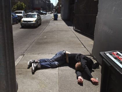 FILE - In this April 26, 2018, file photo, a man lies on the sidewalk beside a recyclable trash bin in San Francisco. A record 621 people died of drug overdoses in San Francisco so far this year, a staggering number that far outpaces the 173 deaths from COVID-19 the …