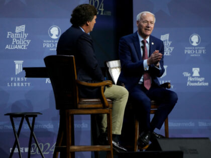 Republican presidential candidate former Arkansas Gov. Asa Hutchinson talks with moderator Tucker Carlson, left, during the Family Leadership Summit, Friday, July 14, 2023, in Des Moines, Iowa. (AP Photo/Charlie Neibergall)