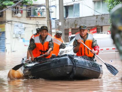 Armed police use a rubber boat to transfer trapped villagers on July 4, 2023, in Chongqing, China. Wanzhou district in Chongqing issued a red rain warning on the morning of July 4 after experiencing several days of heavy rainfalls. (Zou Yi/VCG via Getty Images)