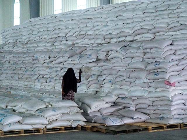 A worker walks next to a pile of sacks of food earmarked for the Tigray and Afar regions in a warehouse of the World Food Programme (WFP) in Semera, the regional capital for the Afar region, in Semera, Ethiopia, Feb. 21, 2022. The United Nations food relief agency has suspended …