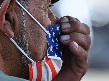 A man adjusts his American flag face mask on July 19, 2021 on a street in Hollywood, California, on the second day of the return of the indoor mask mandate in Los Angeles County due to a spike in coronavirus cases. - The US surgeon general on July 18 defended …