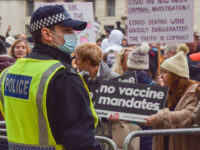 LONDON, UNITED KINGDOM - 2022/01/22: A police officer observes demonstrators during the protest outside Downing Street. Thousands of people marched through Central London in protest against mandatory vaccines for NHS (National Health Service) staff, face masks, Covid-19 vaccines, vaccination passports and various other grievances fueled by conspiracy theories. (Photo by …