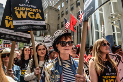 Actor Susan Sarandon, center, with Writers Guild of America members and supporters on a picket line outside NBCUniversal headquarters at 30 Rockefeller Plaza in New York, US, on Tuesday, May 23, 2023. Hollywood screenwriters, on strike for higher pay since May 2, are keeping morale up and pressure on the …