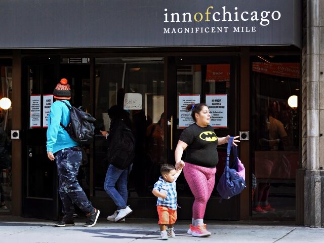 CHICAGO, ILLINOIS - MAY 10: People walk by at the Inn of Chicago, a hotel near the Magnificent Mile in the city's downtown which is being used for temporary housing for newly-arriving migrants on May 10, 2023 in Chicago, Illinois. Chicago Mayor Lori Lightfoot issued a state of emergency on …