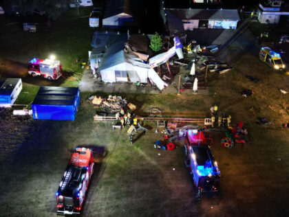 TOPSHOT - This aerial view shows emergency vehicles near the site where a small plane crashed into a hangar at an airfield in the village of Chrcynno, near Warsaw, on July 17, 2023, killing five people. Rescuers said three people were aboard the plane when it collided with the corrugated …