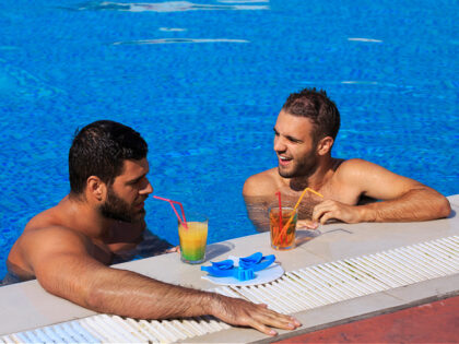 Pool party Friends Two young man relaxing at swimming pool - stock photo