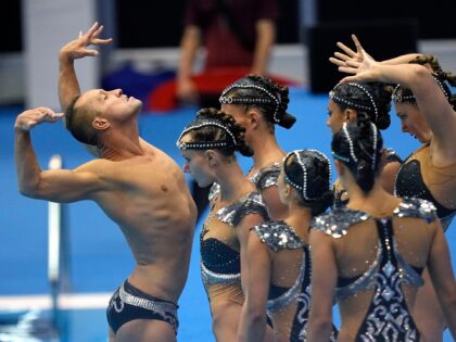 Bill May, left, leads the United States team out to compete in the team acrobatic of artistic swimming at the World Swimming Championships in Fukuoka, Japan, Saturday, July 15, 2023. Largely unoticed by the general public, men have been participating in artistic swimming, formerly known as synchronized swimming, for decades. …