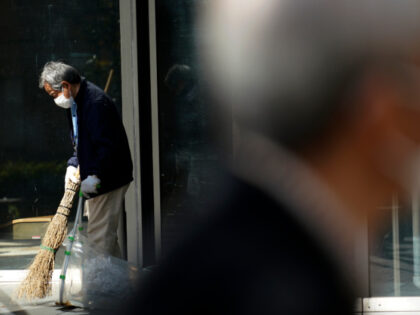A man wearing a protective face mask sweeps the entrance to a building Thursday, April 2, 2020, in Tokyo. The new coronavirus causes mild or moderate symptoms for most people, but for some, especially older adults and people with existing health problems, it can cause more severe illness or death. …