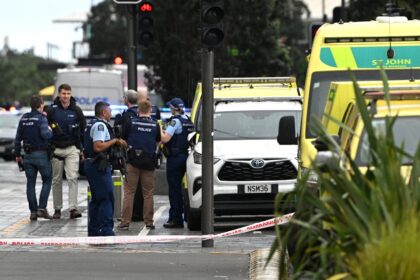 Police officers cordon off the site of a shooting in central Auckland