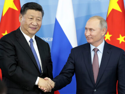 Russia's President Vladimir Putin (R) shakes hands with his China's counterpart Xi Jinping during a signing ceremony following the Russian-Chinese talks on the sidelines of the Eastern Economic Forum in Vladivostok on September 11, 2018. (Photo by SERGEI CHIRIKOV / POOL / AFP) (Photo credit should read SERGEI CHIRIKOV/AFP via …
